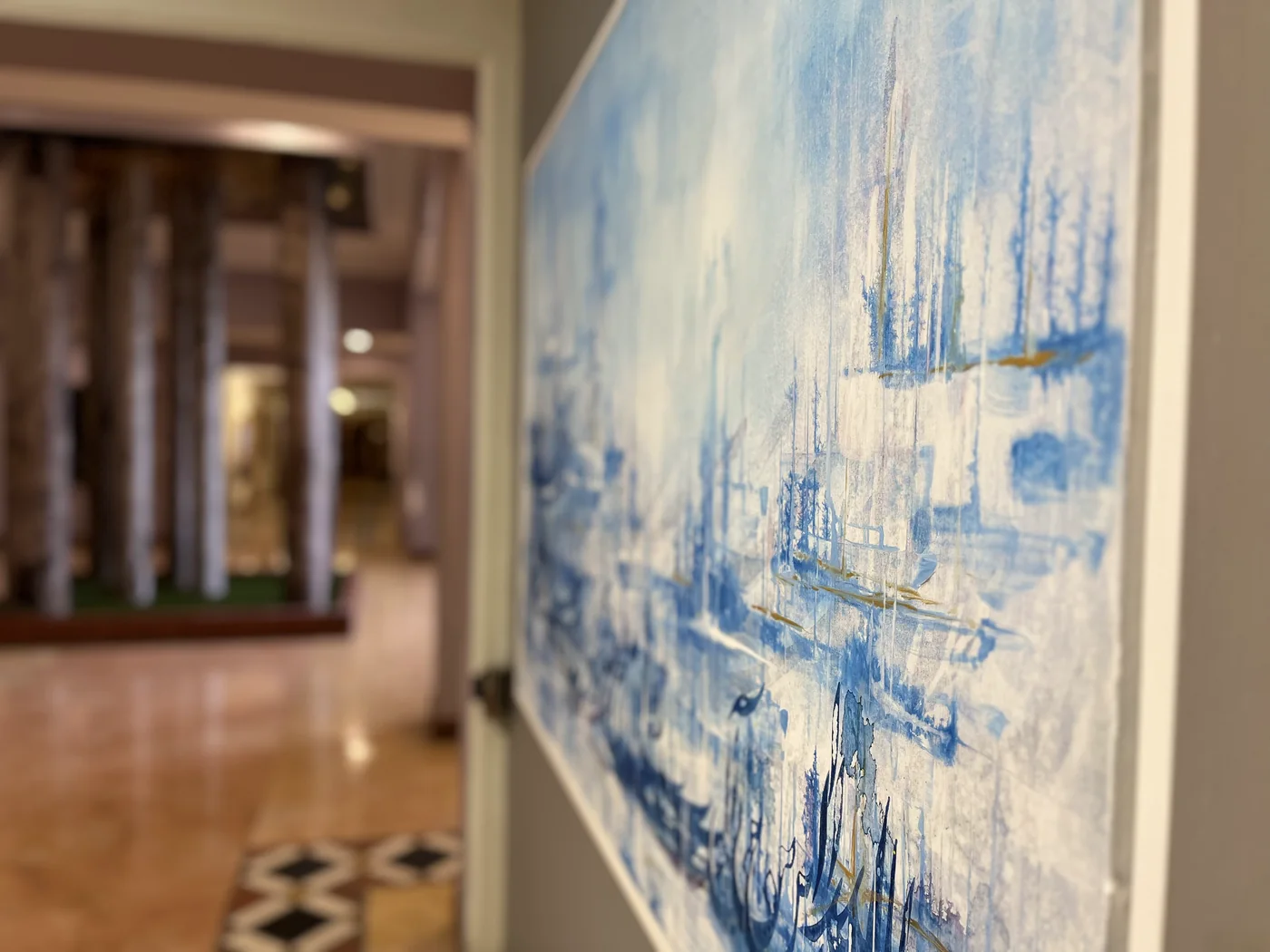 A large blue abstract painting seen from the side, next to an open gallery doorway
